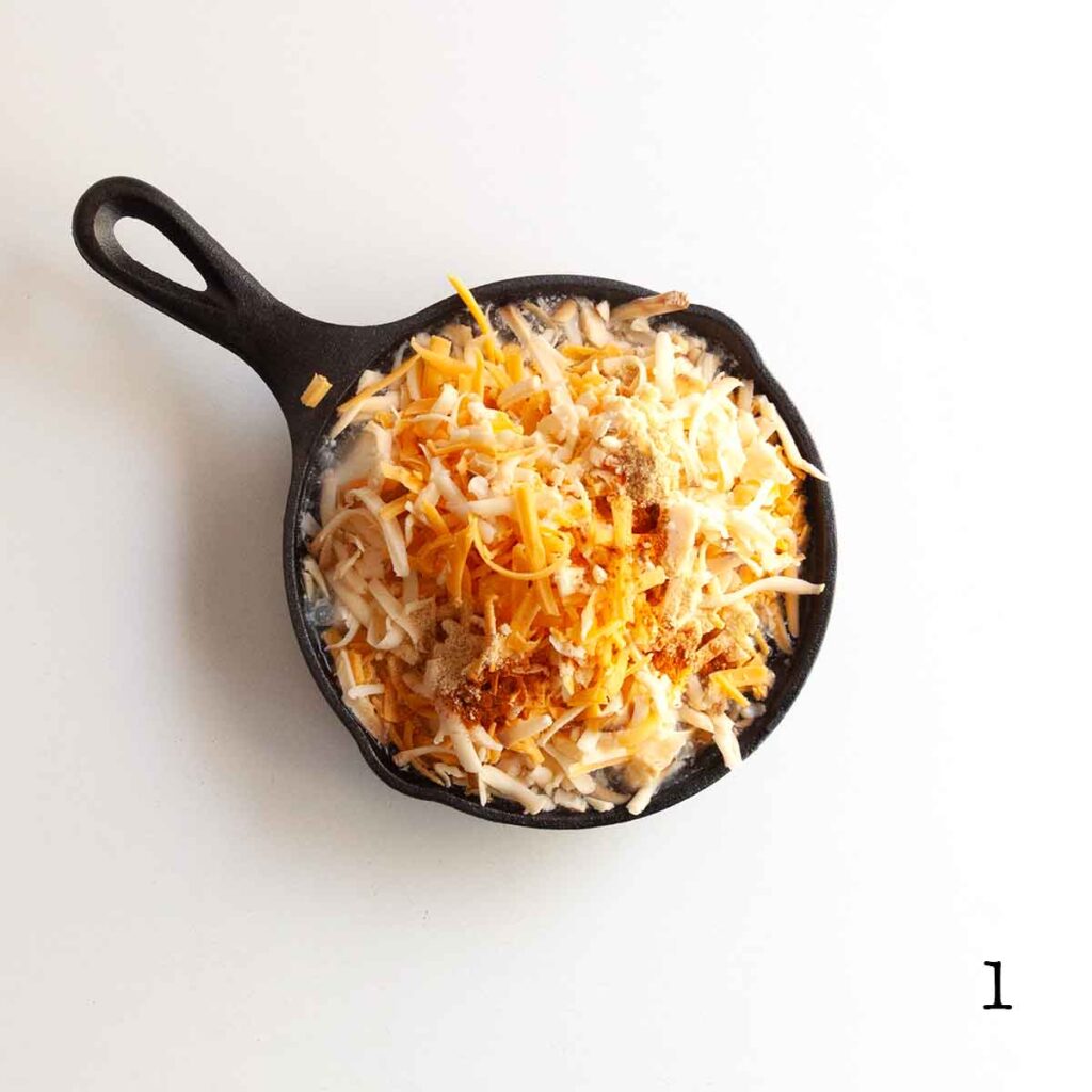 A small cast iron skillet filled with cheese and spices.