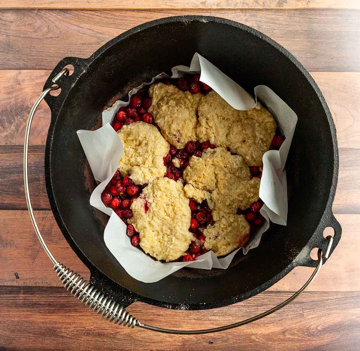 Cranberry cobbler with biscuit topping in a Dutch oven.