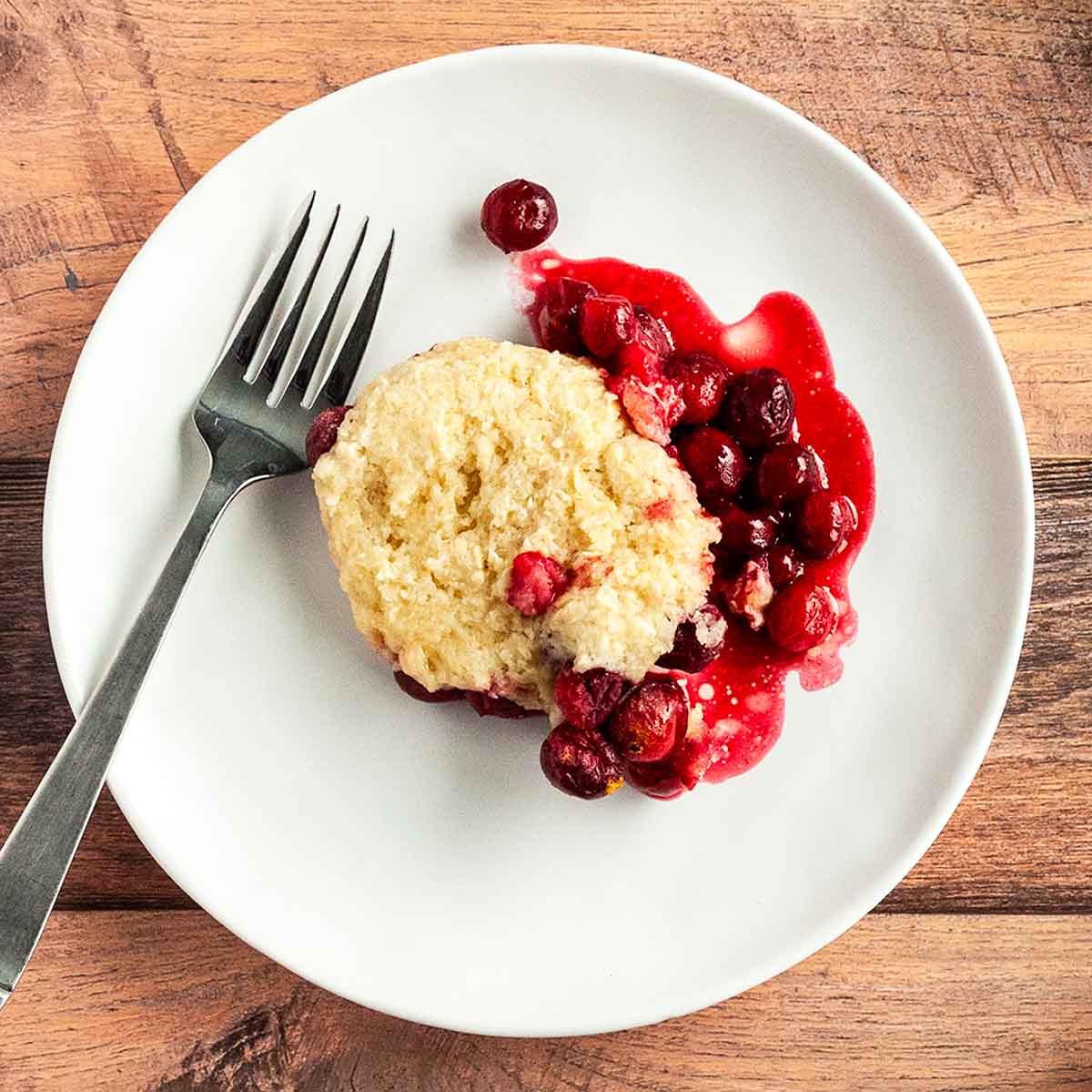 A serving of cranberry cobbler on a white plate.
