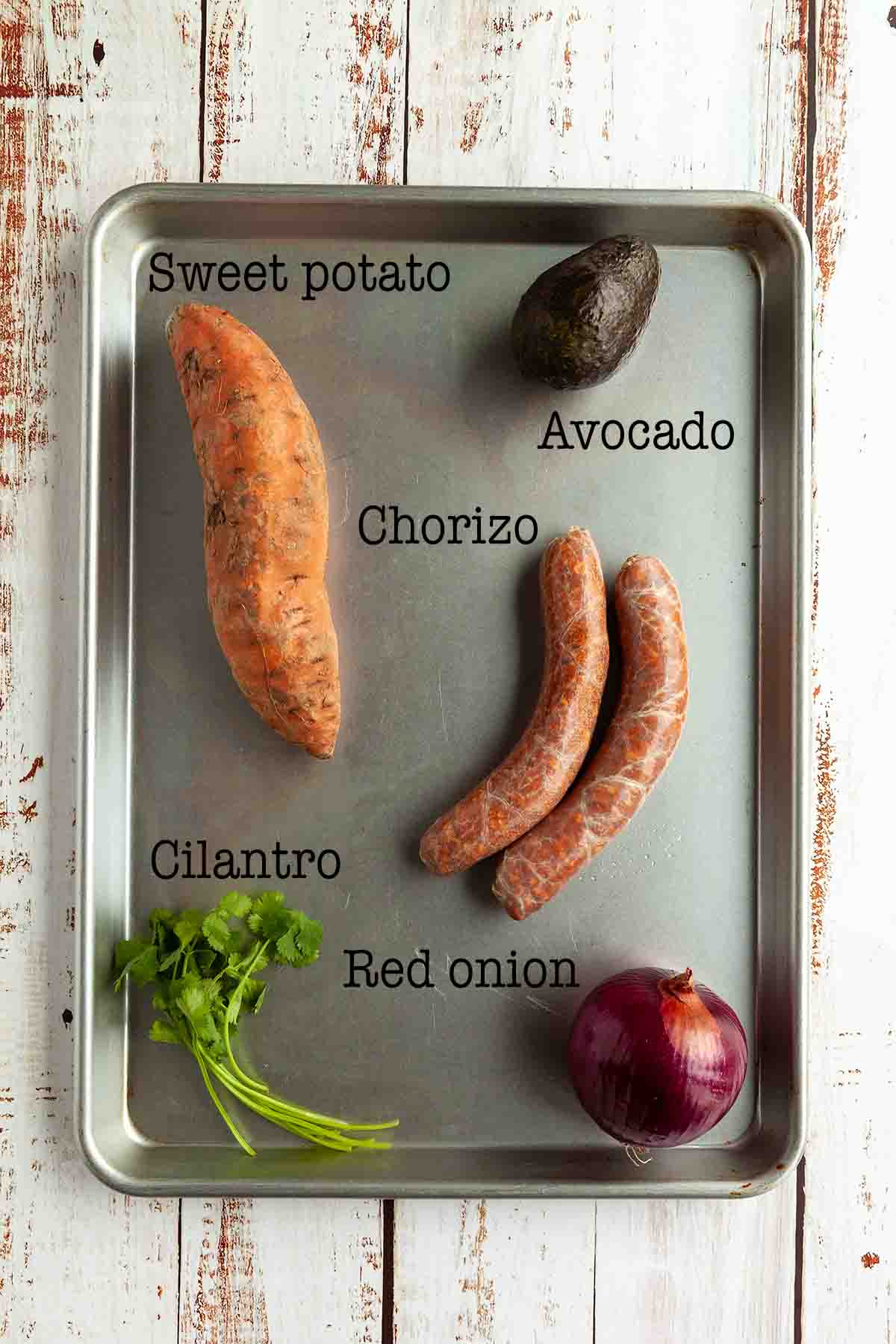 Ingredients for chorizo sweet potato hash--sweet potato, avocado, chorizo sausage, cilantro, and red onion.