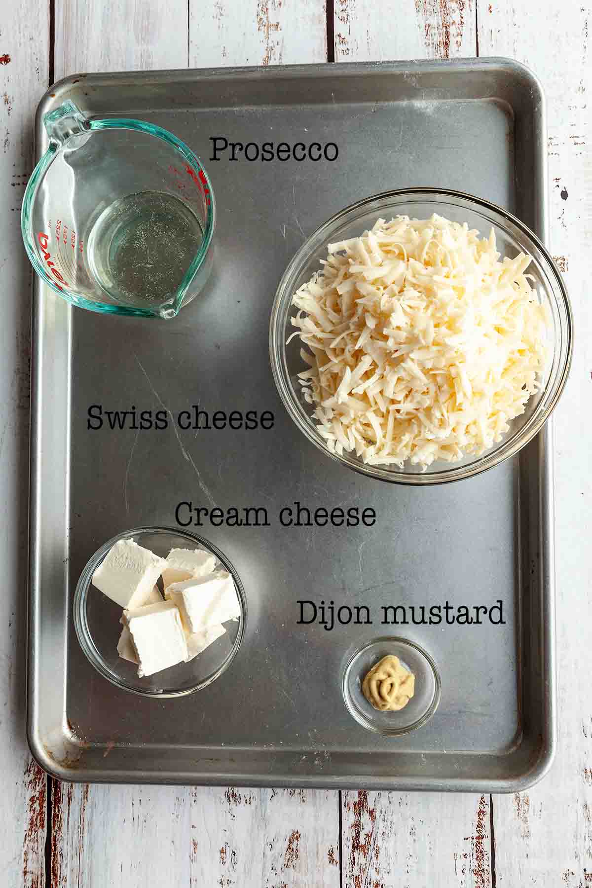 Ingredients for Swiss cheese dip--Prosecco, Swiss cheese, cream cheese, and Dijon mustard.