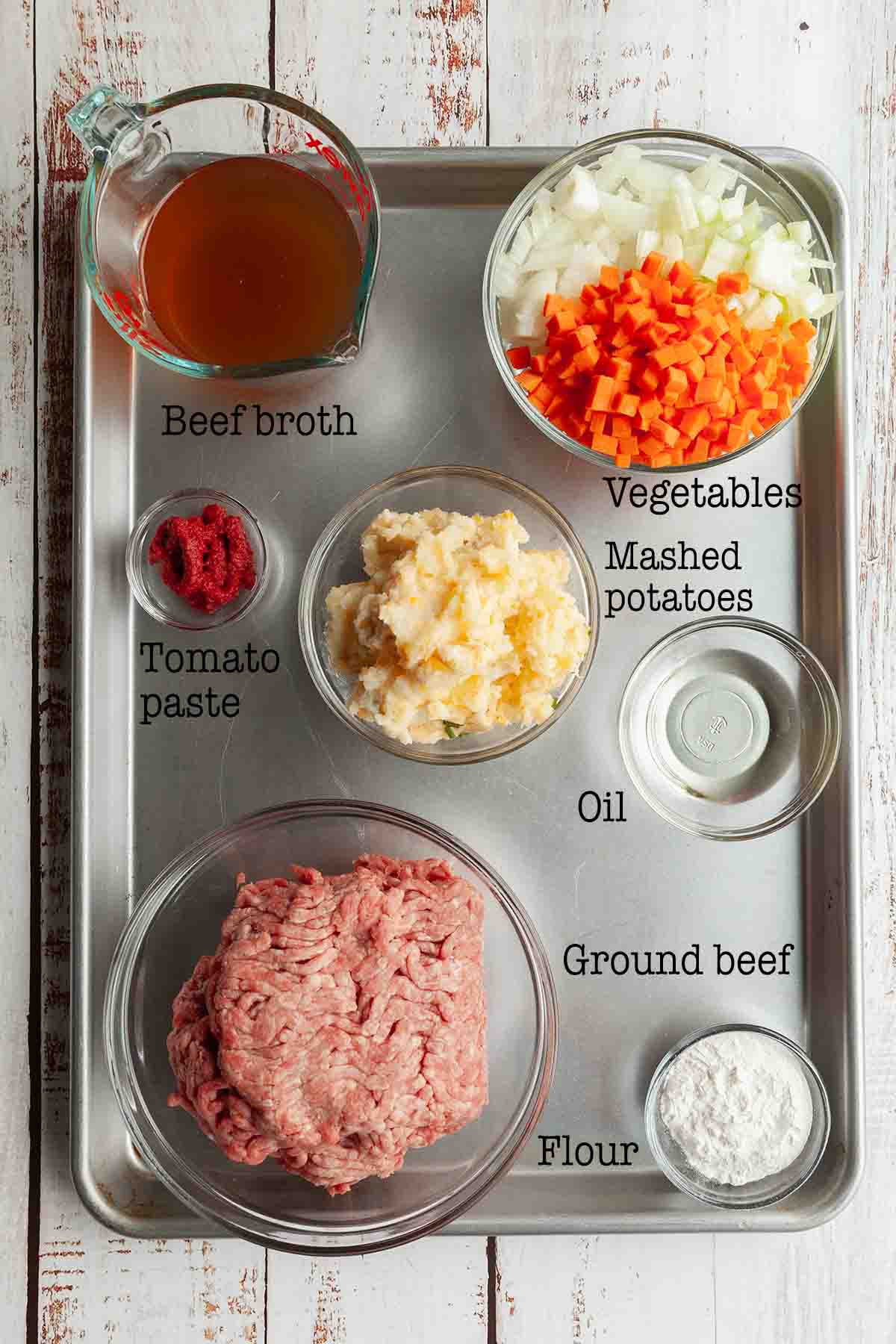 Ingredients for Dutch oven shepherd's pie--beef, vegetables, broth, tomato paste, oil, flour, and mashed potatoes.