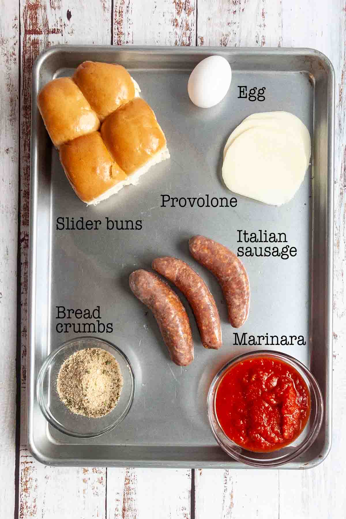 Ingredients for Italian sausage sliders--buns, Provolone, egg, sausage, bread crumbs, and marinara.