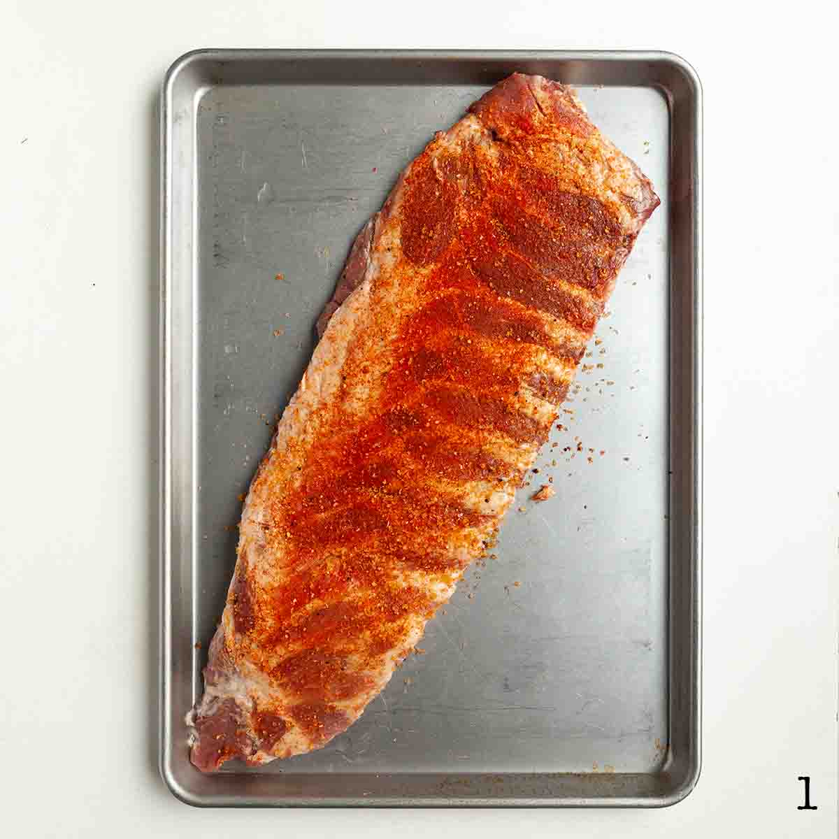 A rack of spare ribs coated with rub.