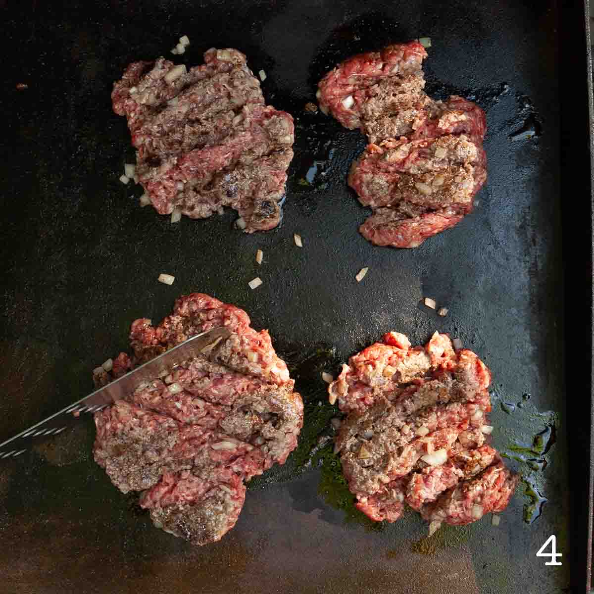 Ground beef patties being chopped into pieces.