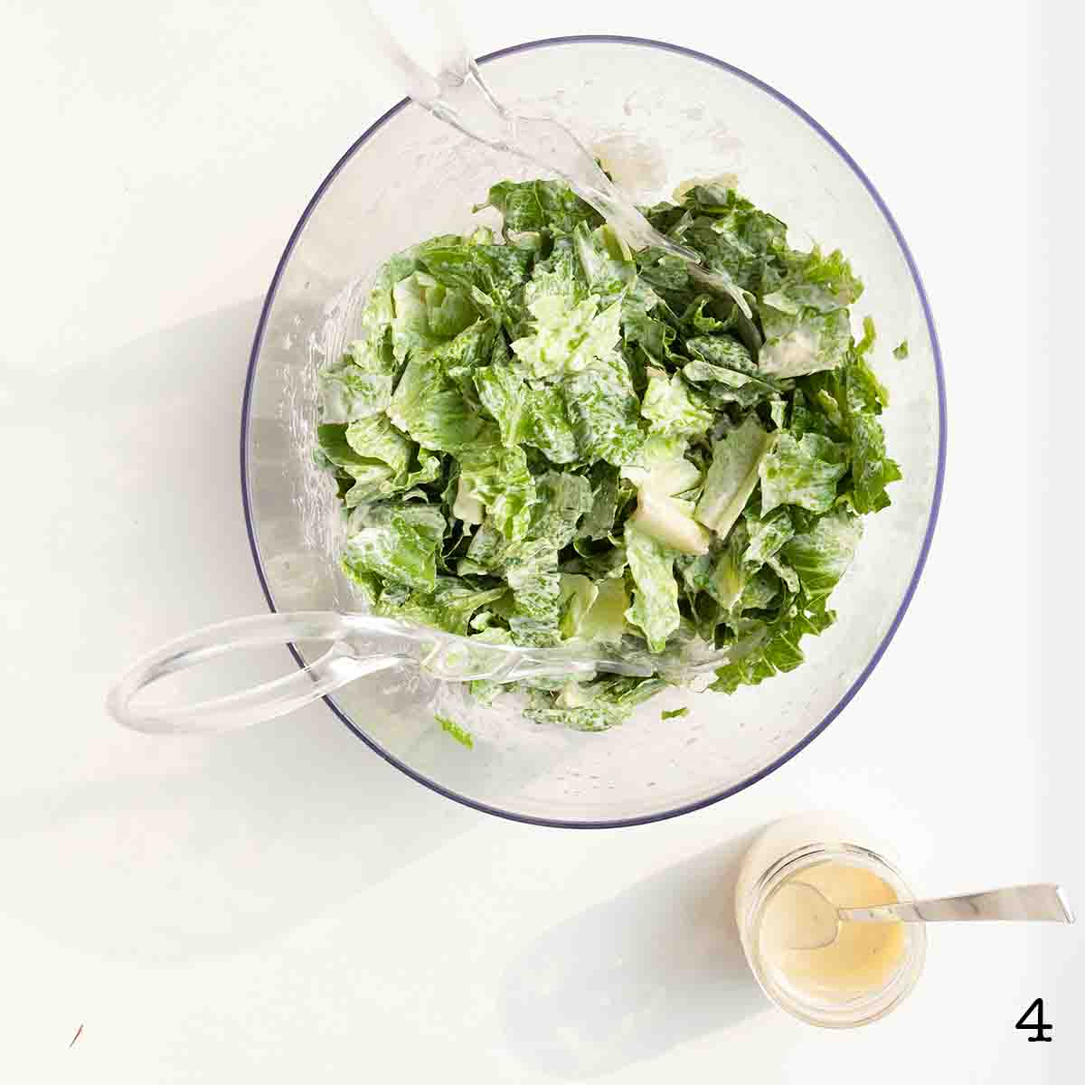 A bowl of romaine lettuce tossed in dressing.