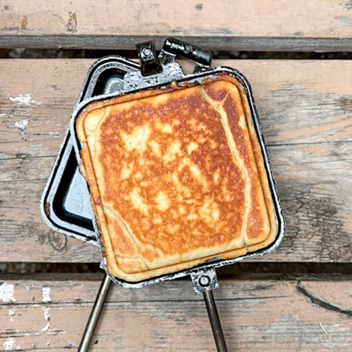 A cooked pie iron pizza in a open pie iron.