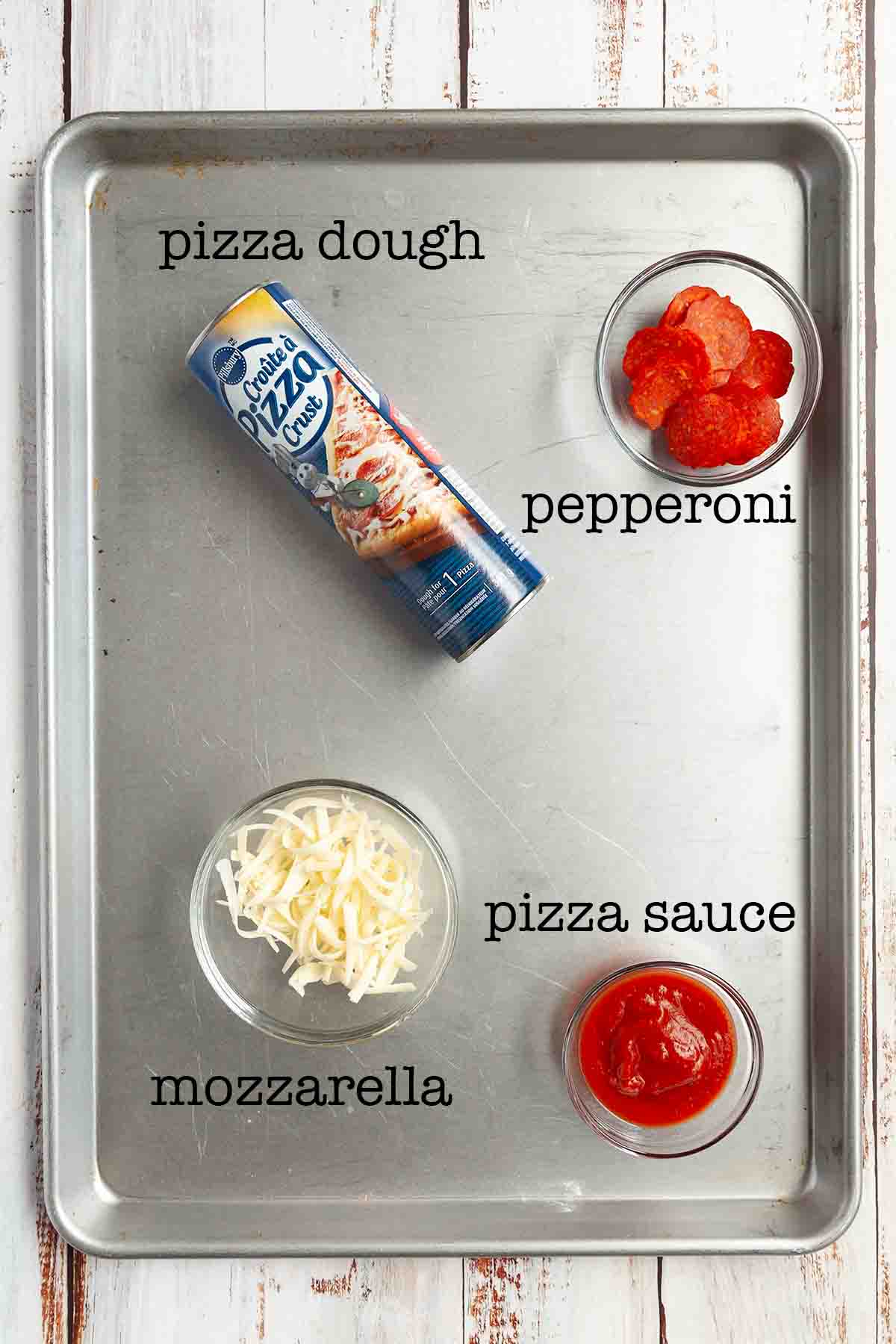 Ingredients for pie iron pizza--pizza dough, pepperoni, cheese, and sauce.