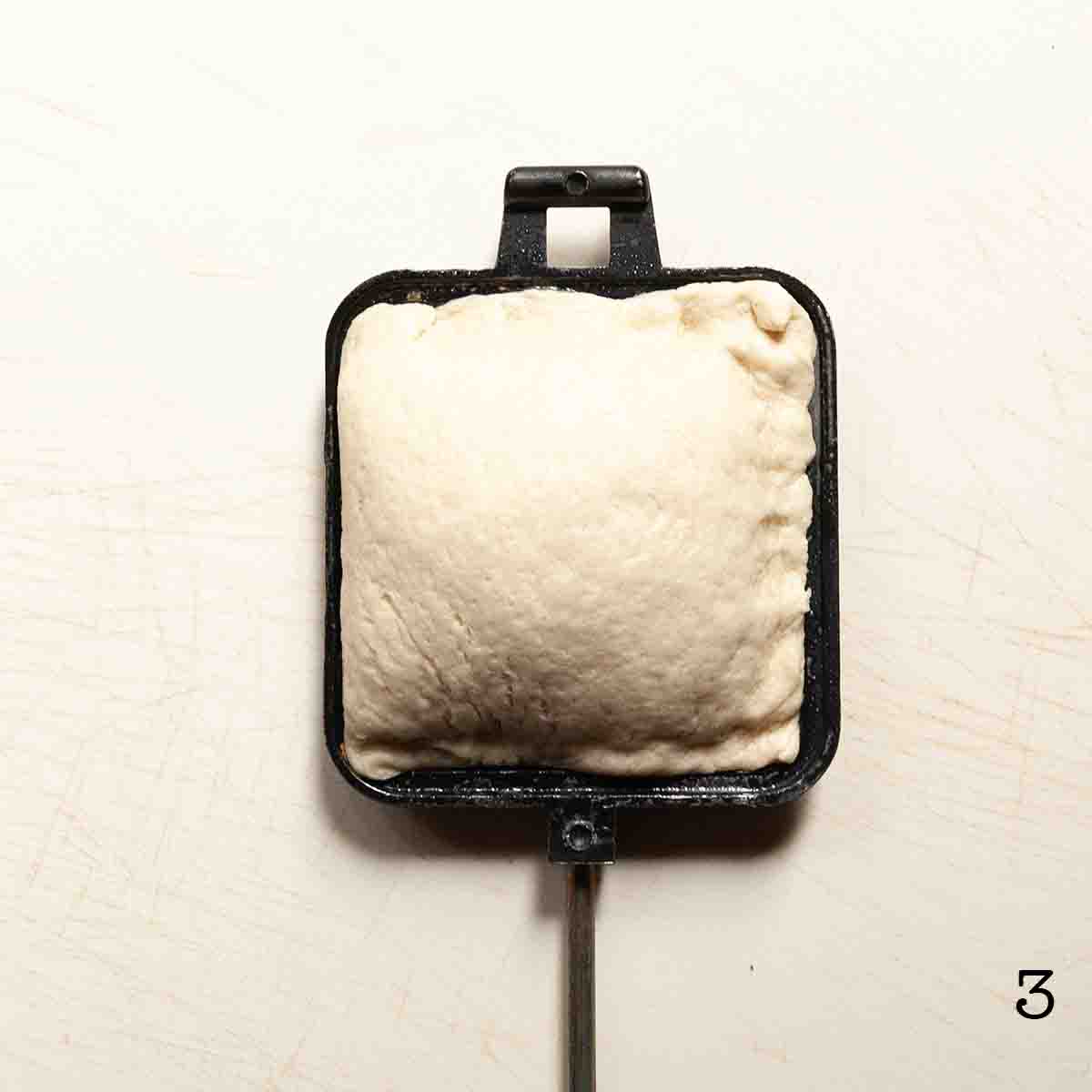 A sealed pie iron pizza.