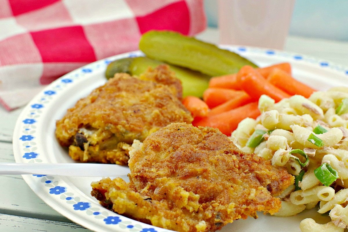 Two pieces of fried chicken on a paper plate.