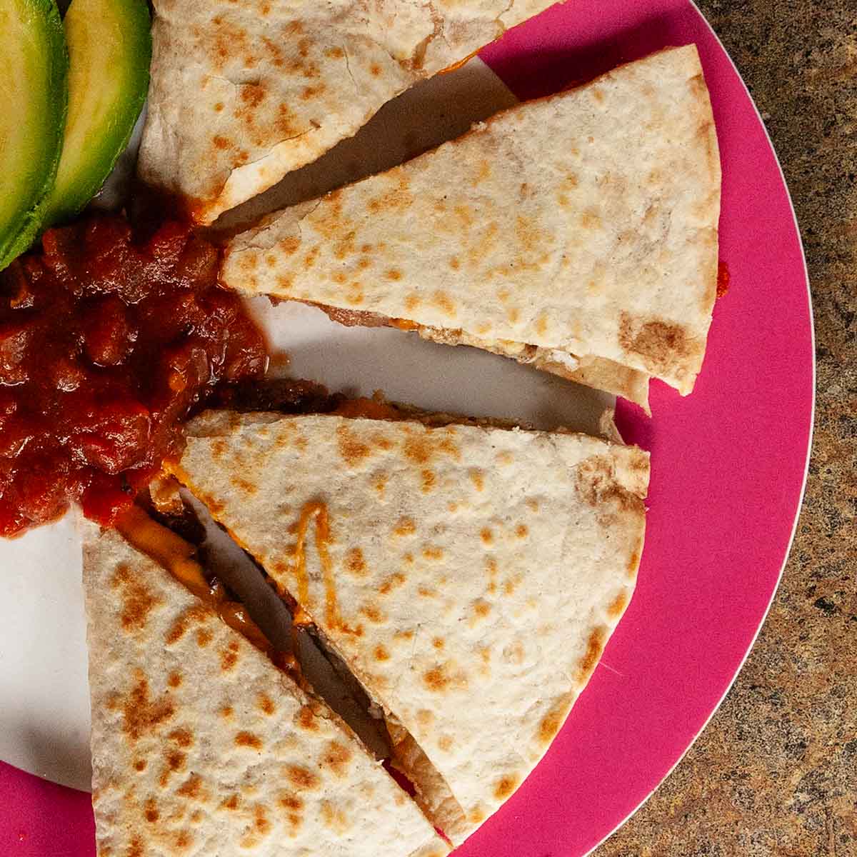 A breakfast quesadilla cut into four pieces.