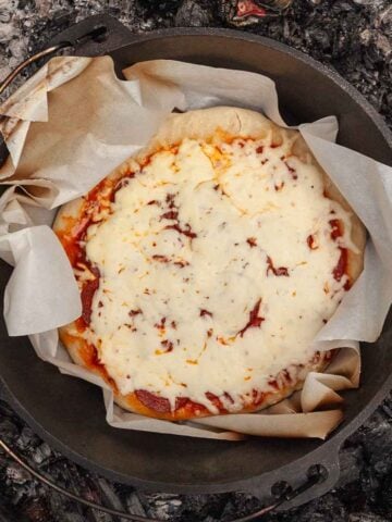 A cooked pizza in a Dutch oven.
