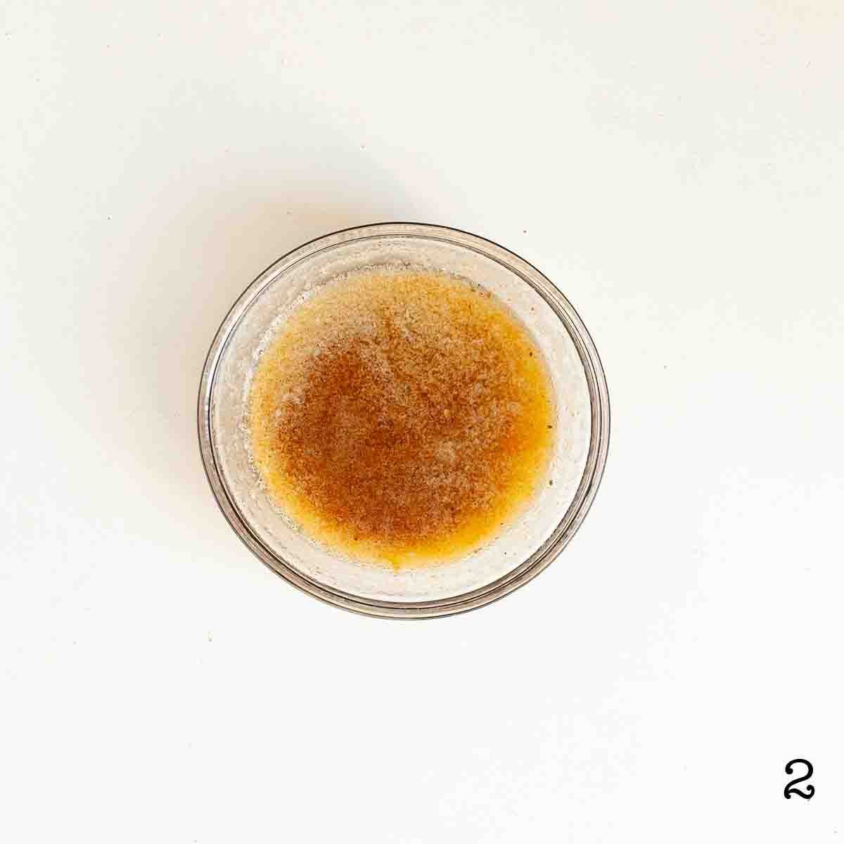 A bowl of melted butter mixed with Old Bay seasoning.