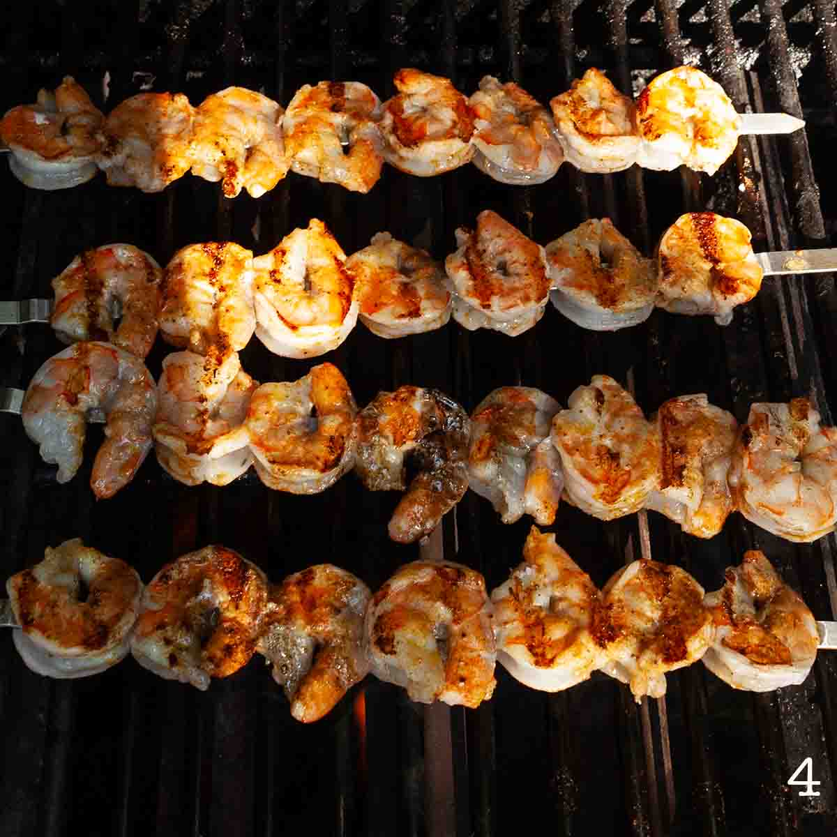 Four shrimp skewers on the grill.