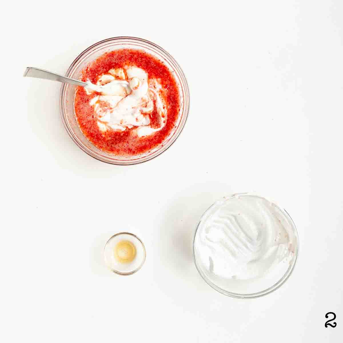 Greek yogurt and strawberry puree being mixed together in a bowl.