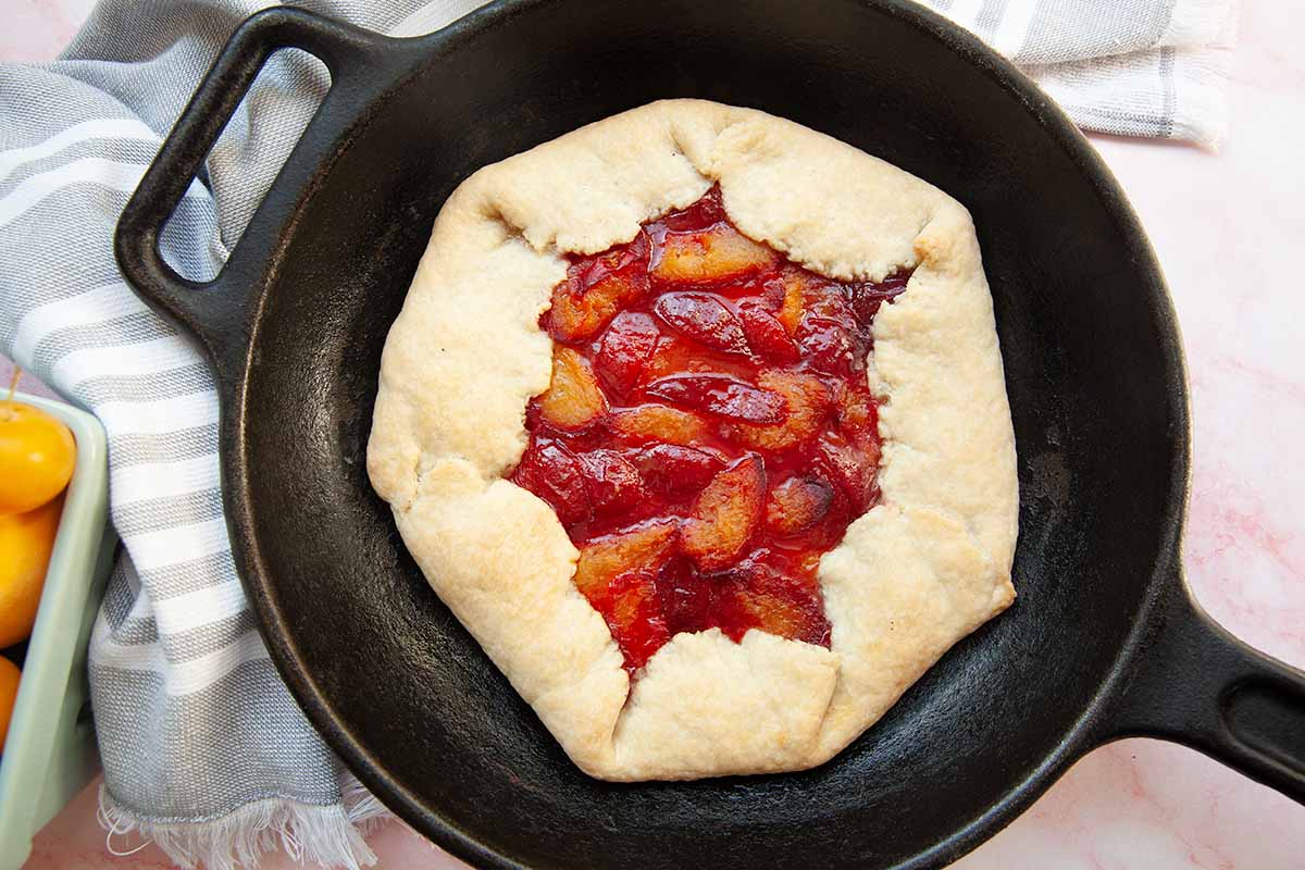 A plum galette in a cast iron skillet.