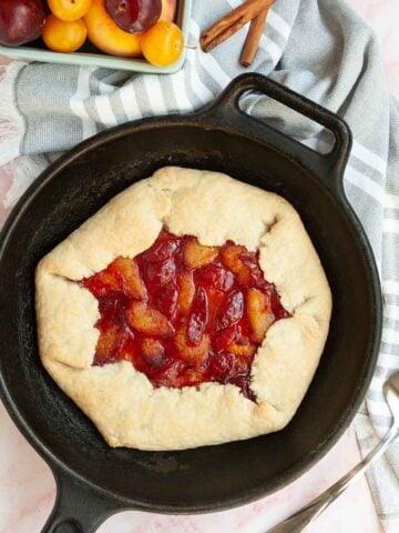 A plum galette in a cast iron skillet.