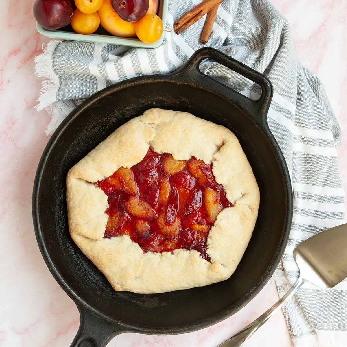 A plum galette in a cast iron skillet.