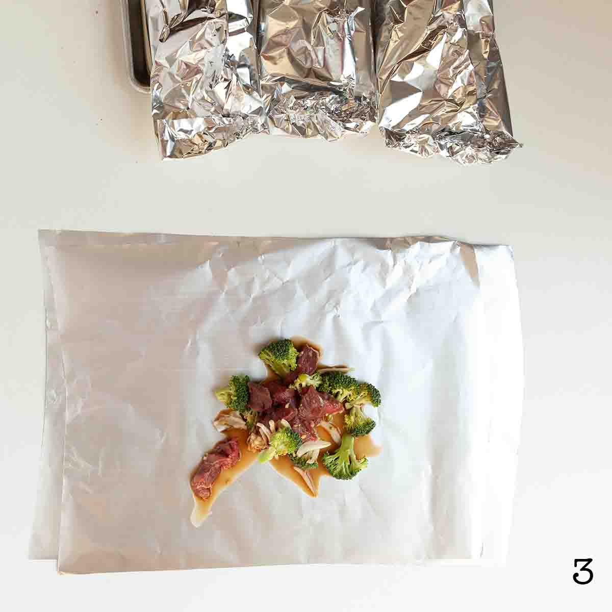 A scoop of beef and broccoli mixture on a foil sheet.