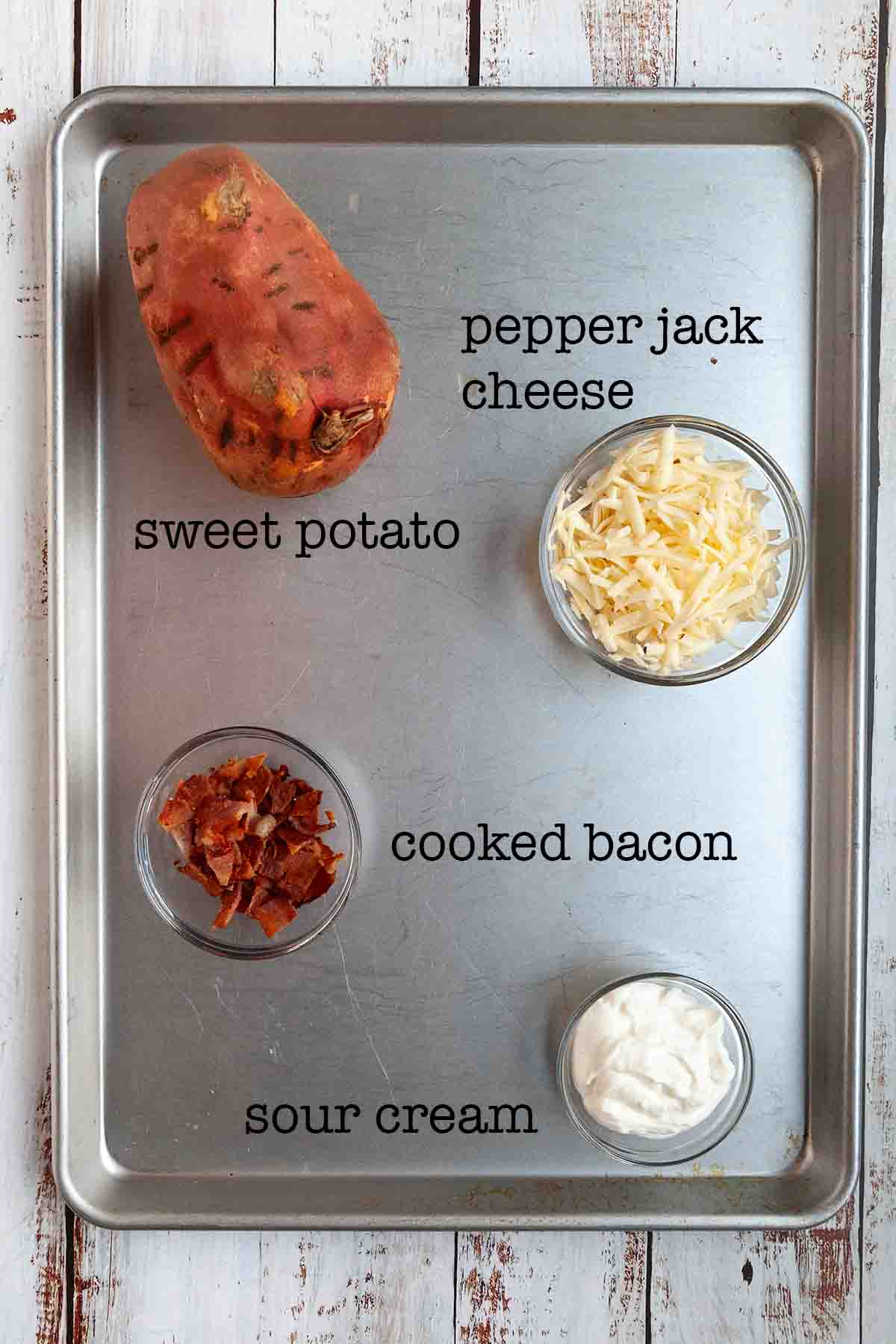 Ingredients for smoked sweet potato casserole--sweet potato, pepper jack cheese, cooked bacon, and sour cream.