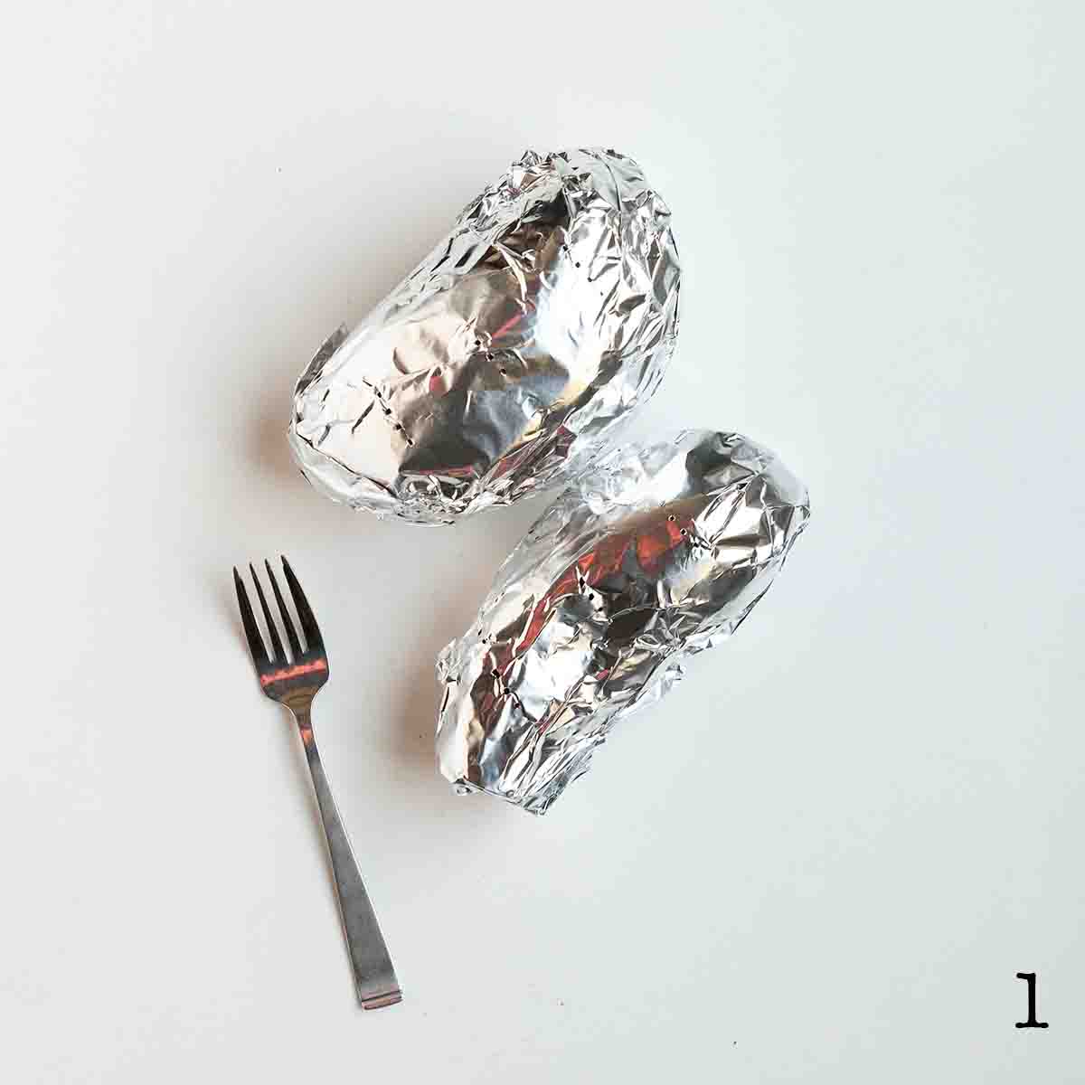 Two sweet potatoes wrapped in foil.