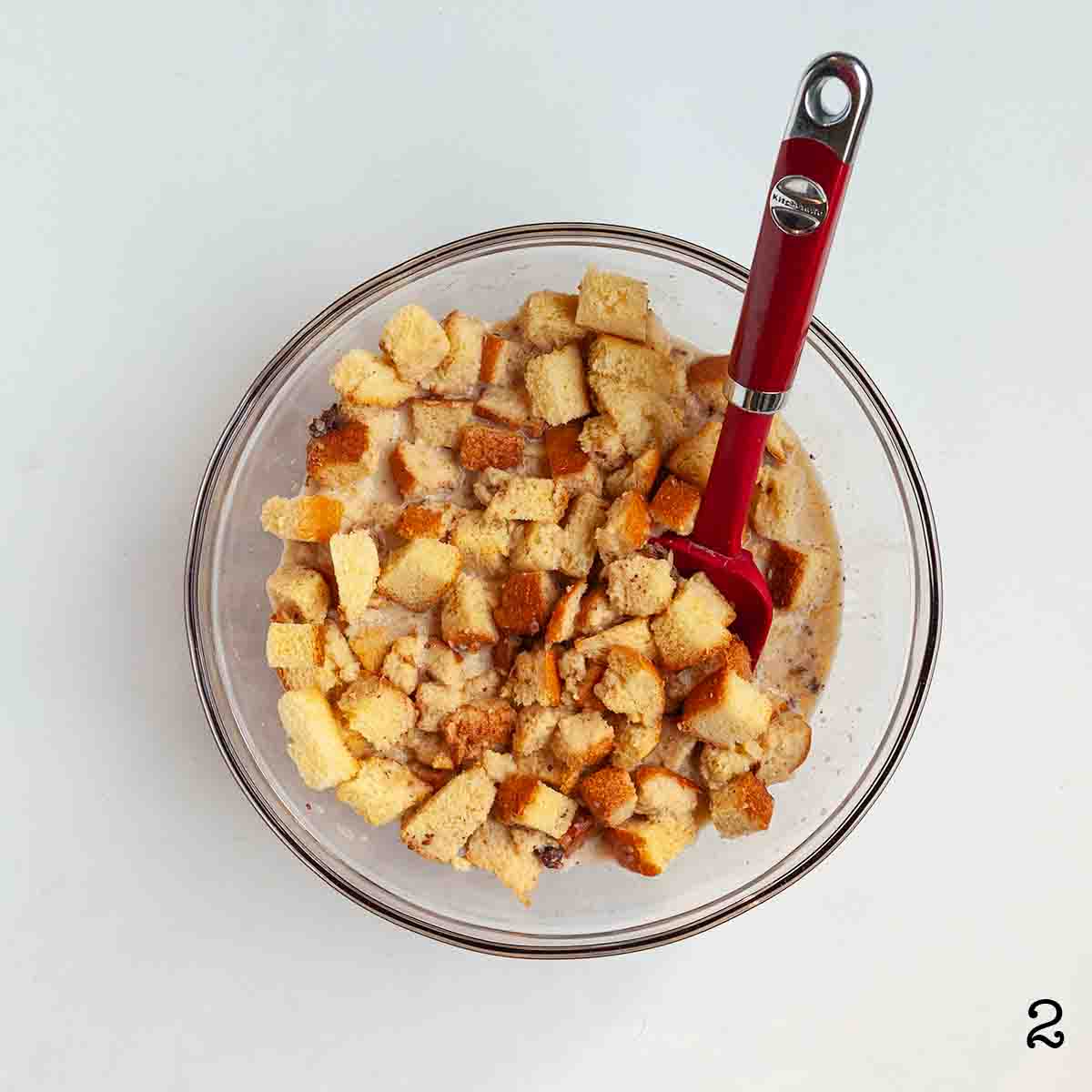 A bowl of cubed brioche bread in custard.