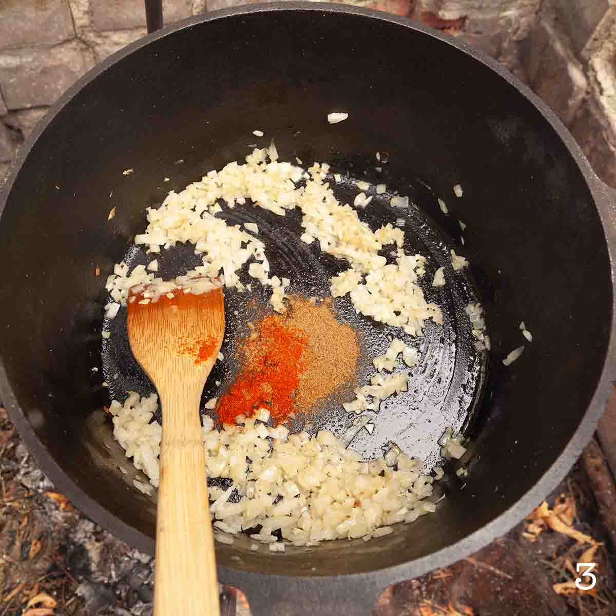 Spices added to a Dutch oven with onion, ginger, and garlic.