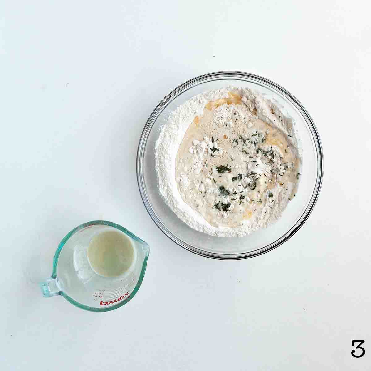Liquid ingredients added to dry ingredients in a mixing bowl.
