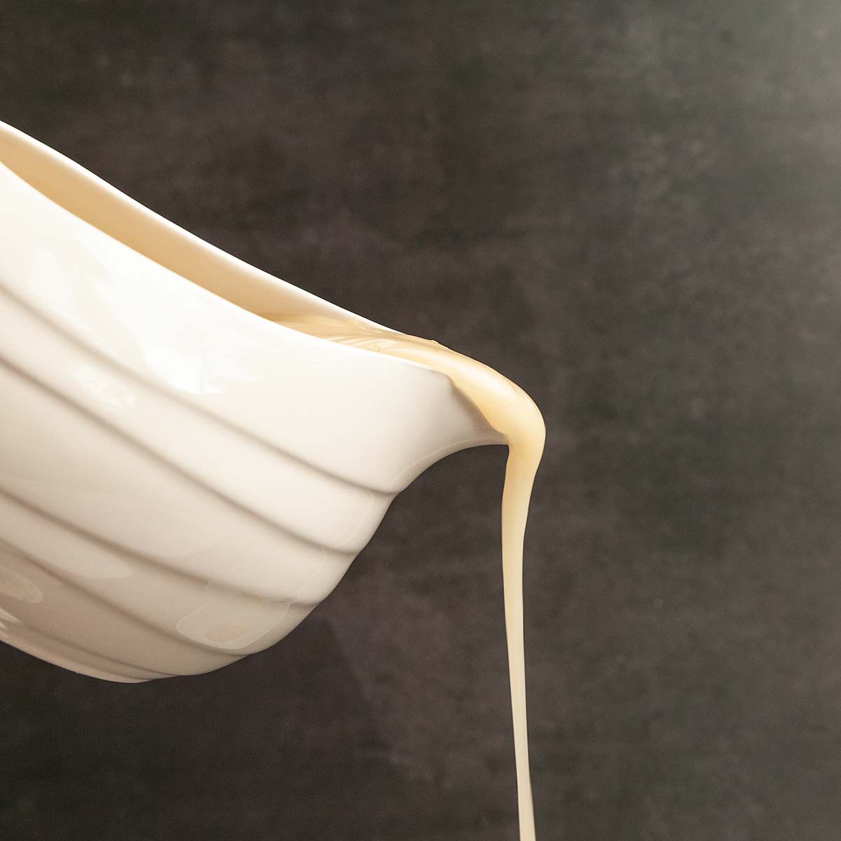 Gravy being poured from a pitcher.