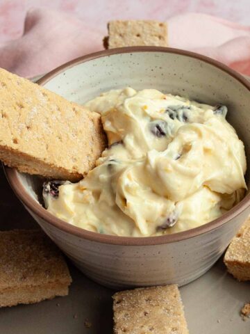 A bowl of dip with shortbread fingers around it and one resting inside.