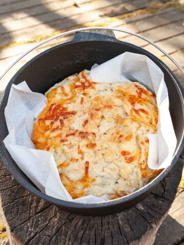 A loaf of cheddar beer bread in a Dutch oven.