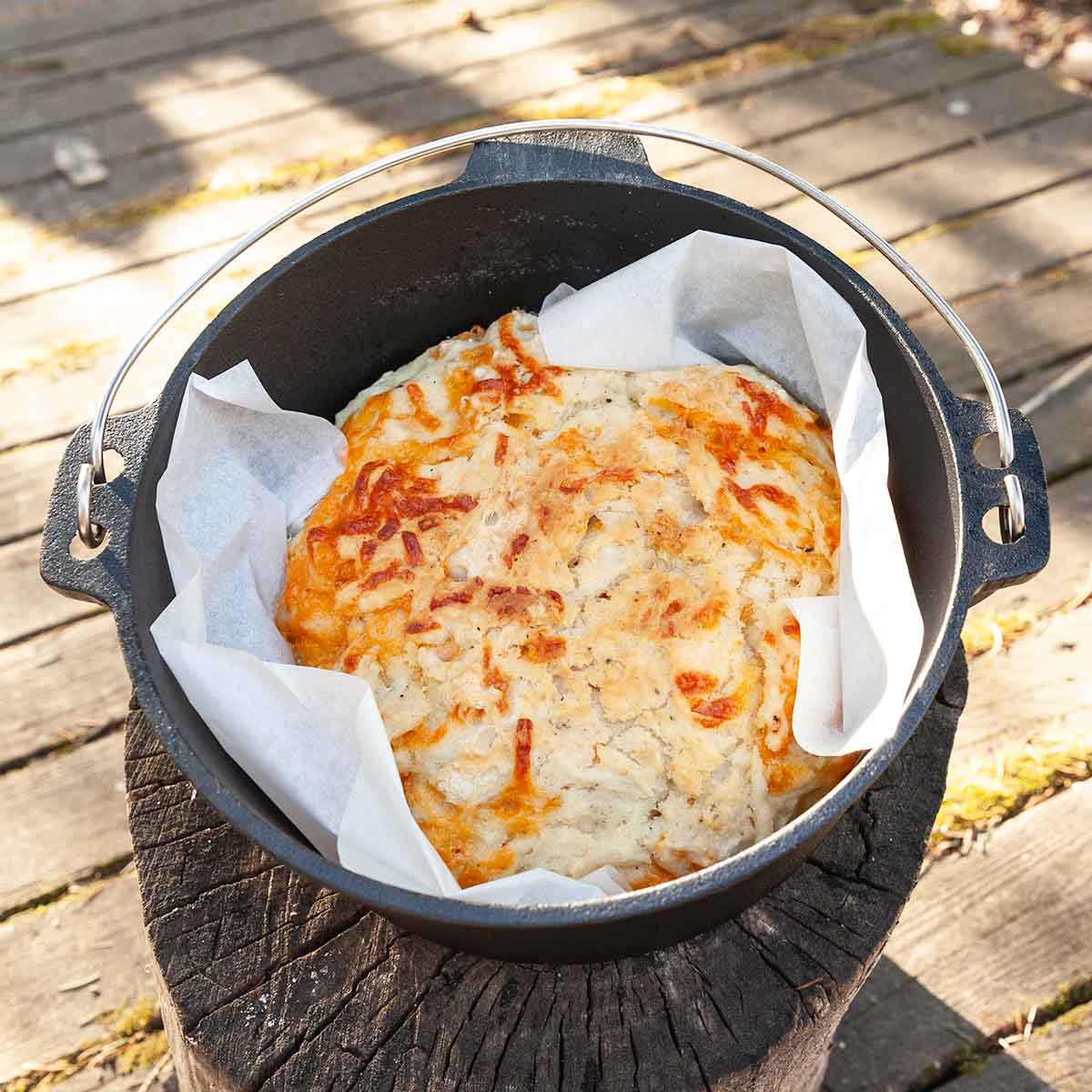 A loaf of cheddar beer bread in a Dutch oven.