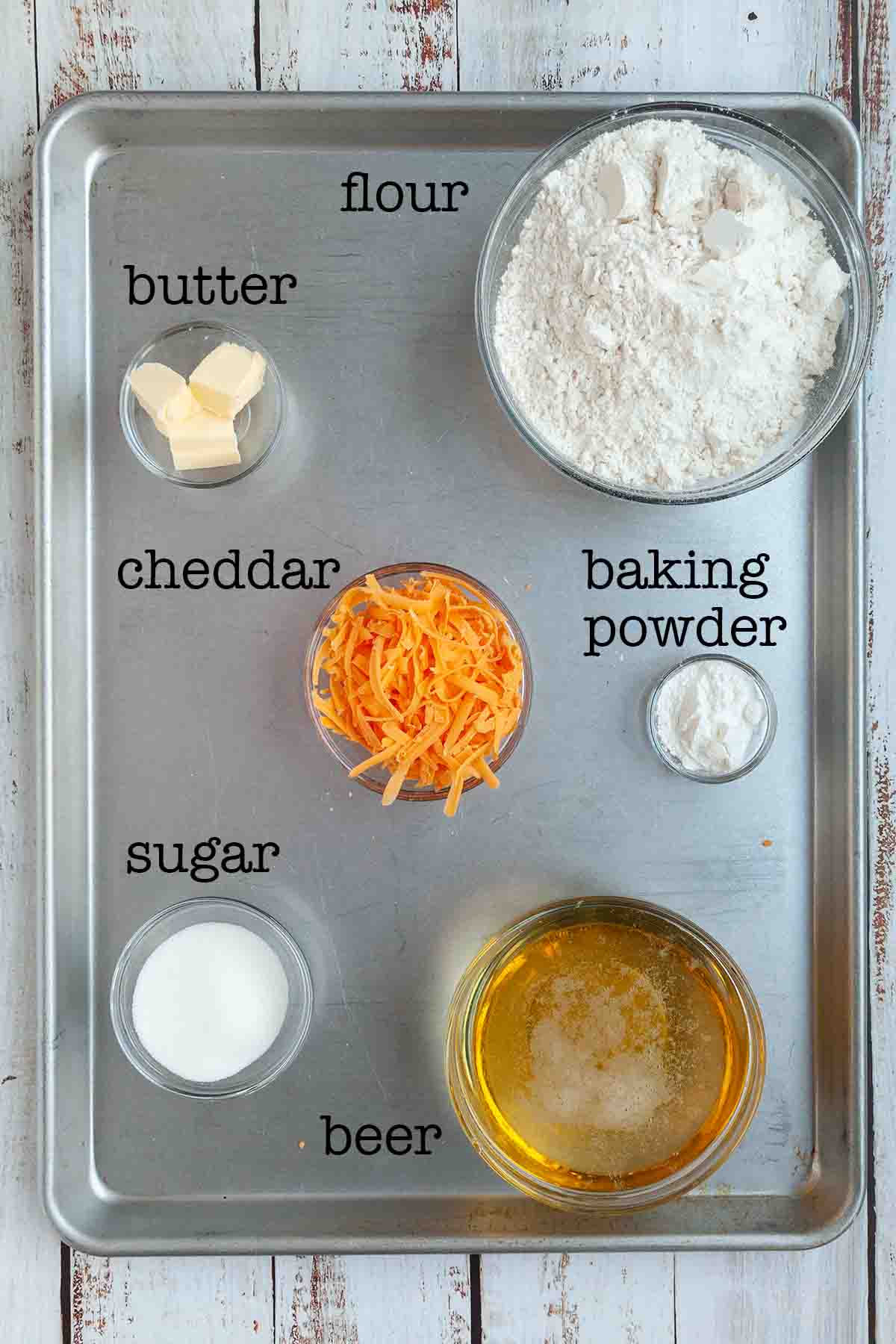 Ingredients for Dutch oven beer bread--flour, butter, cheddar, baking powder, sugar, and beer.