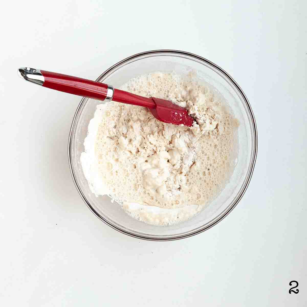 Wet and dry ingredients being mixed together in a bowl.