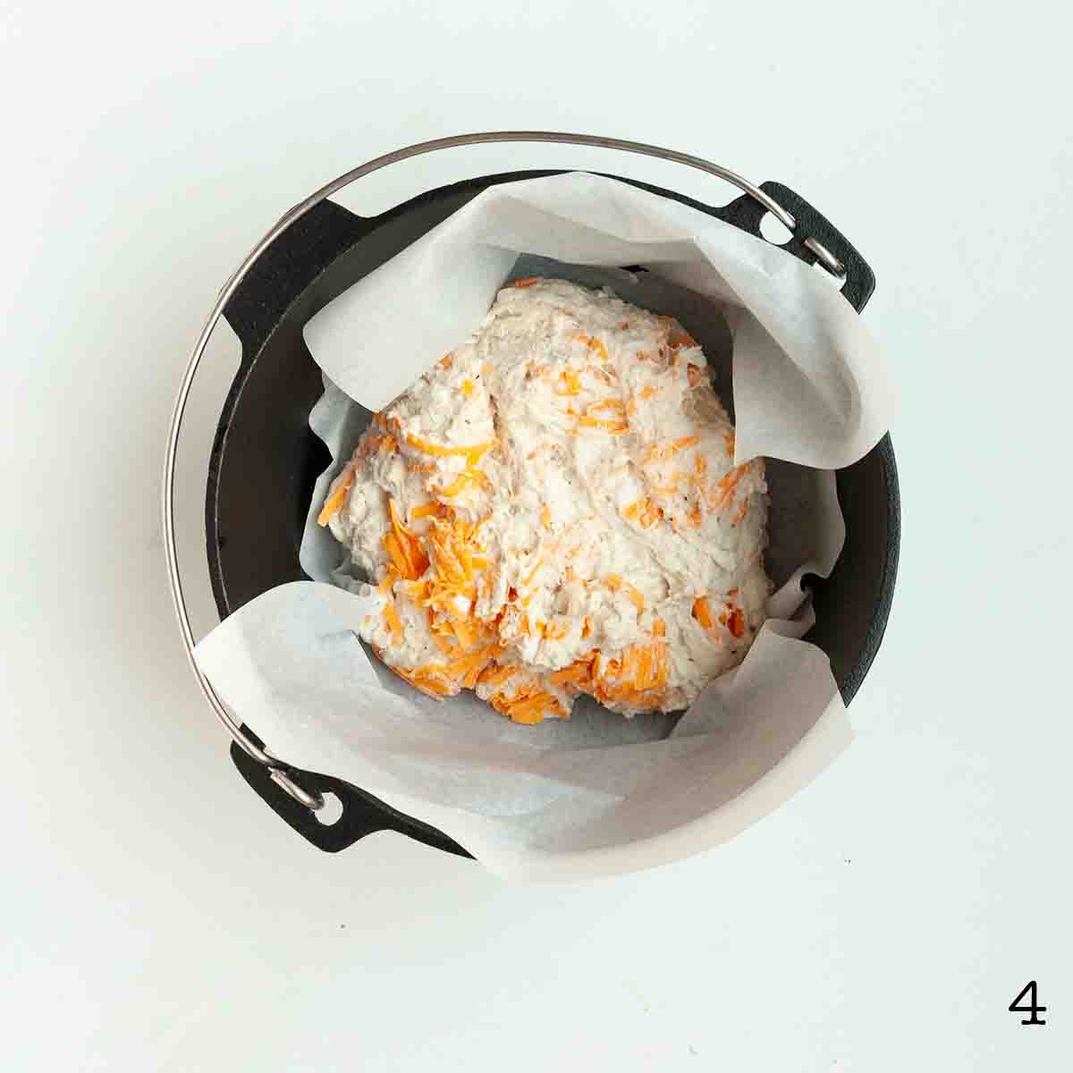 An uncooked mound of bread dough in a Dutch oven.