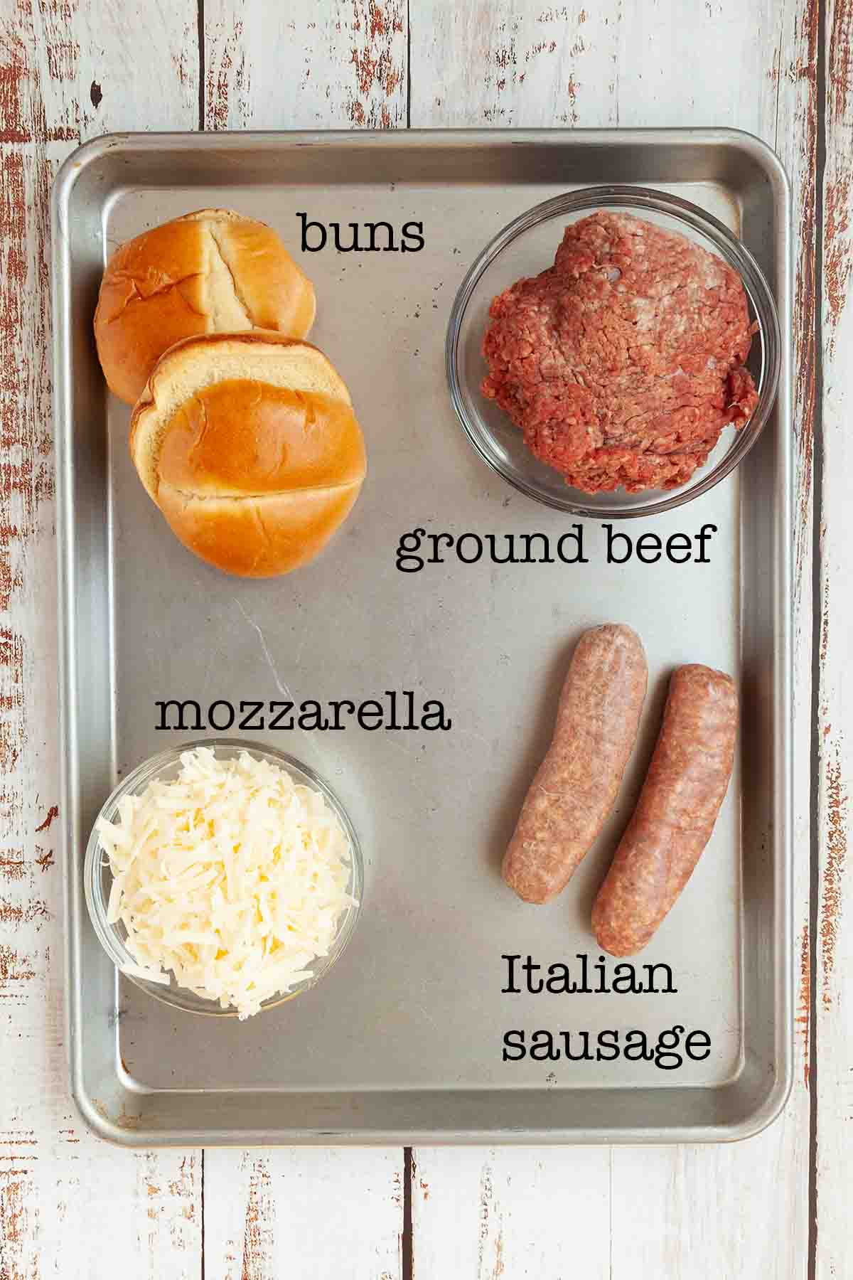 Ingredients for beef and sausage burgers--buns, ground beef, mozzarella, and Italian sausage.