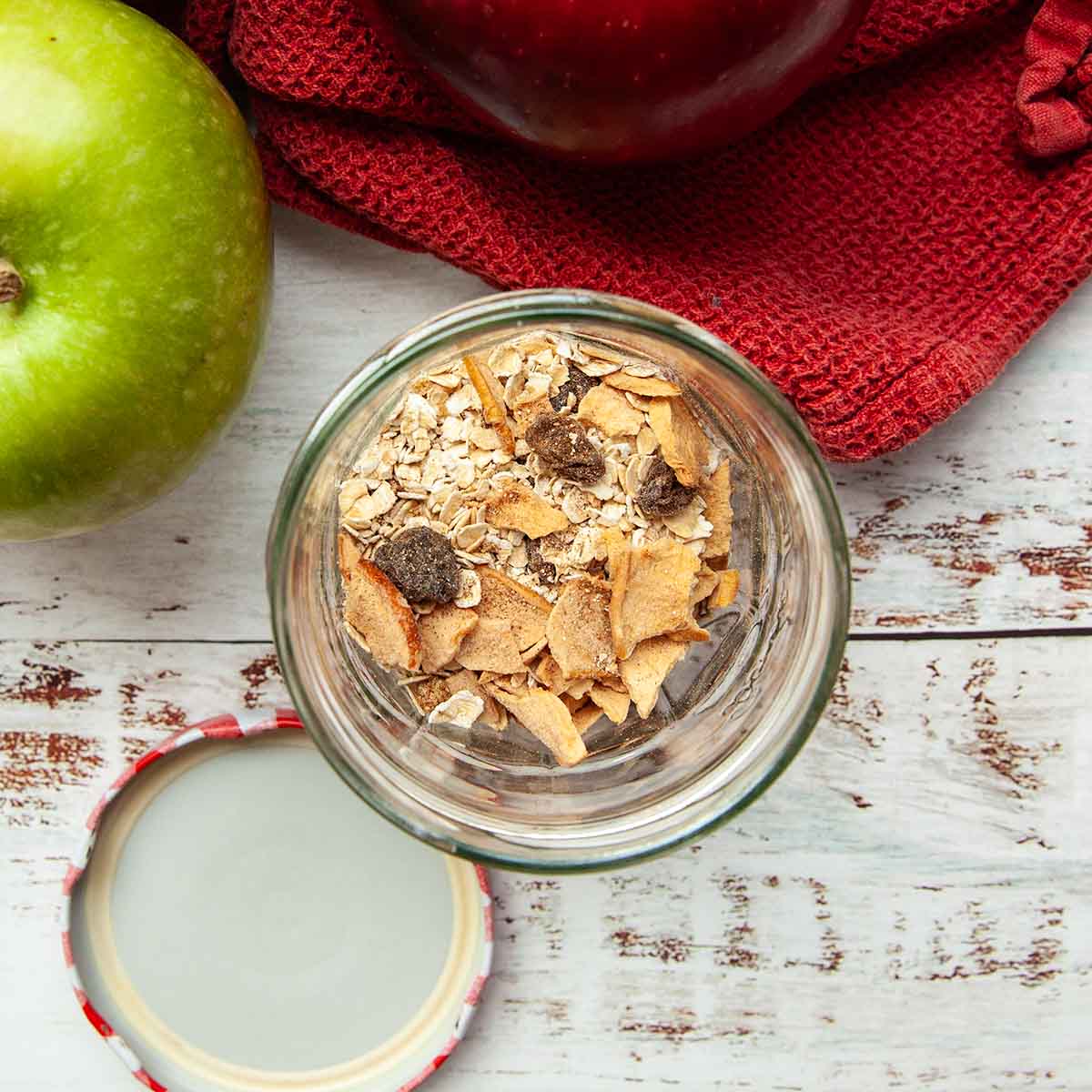 A jar half filled with oats and dried fruits.