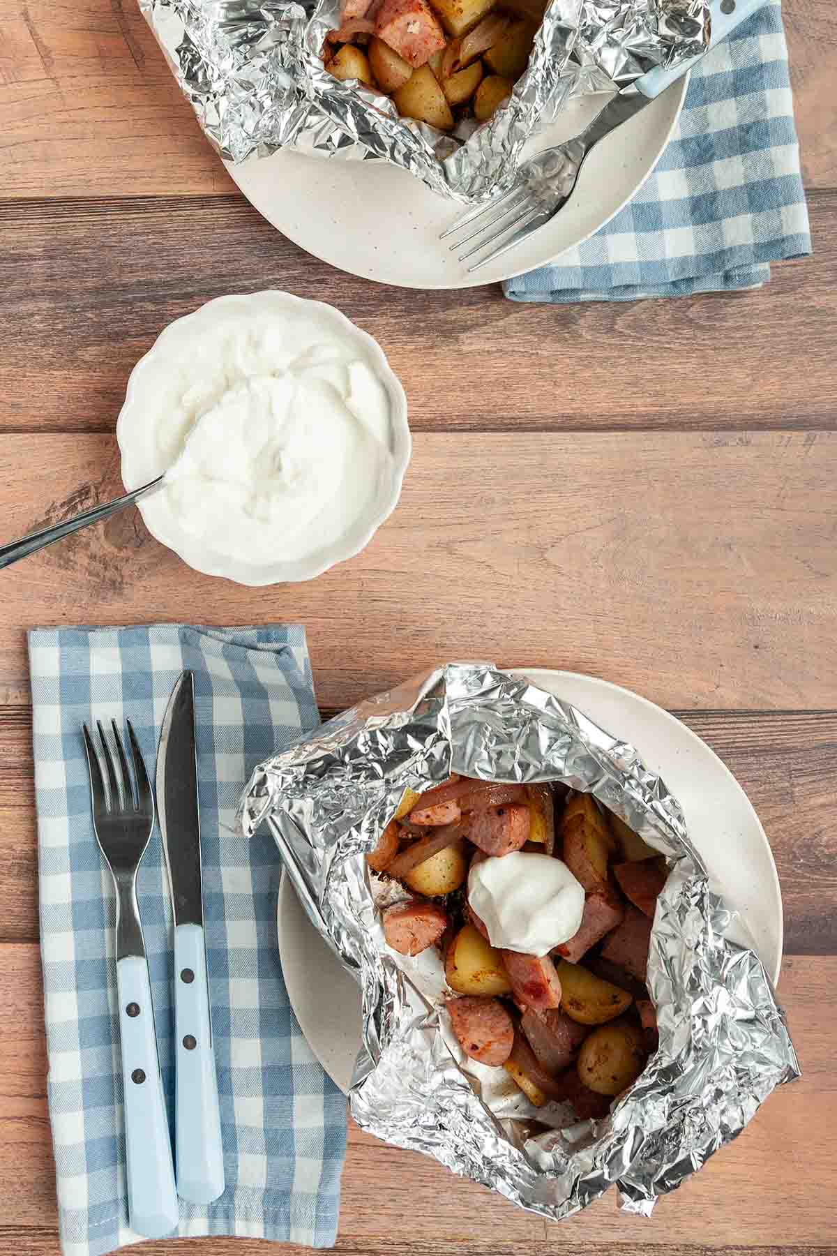Two sausage and potato foil packets.