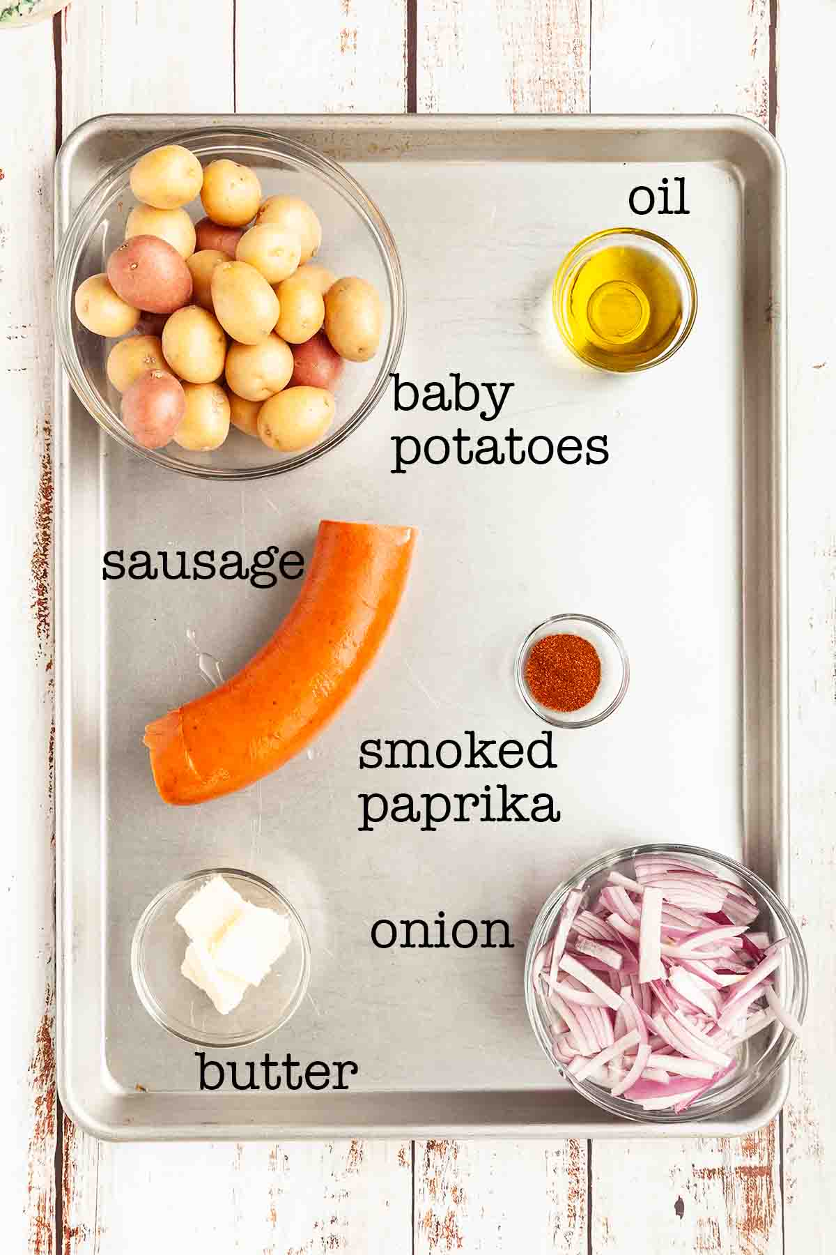 Ingredients for sausage and potato foil packets--baby potatoes, oil, sausage, smoked paprika, onion, and butter.