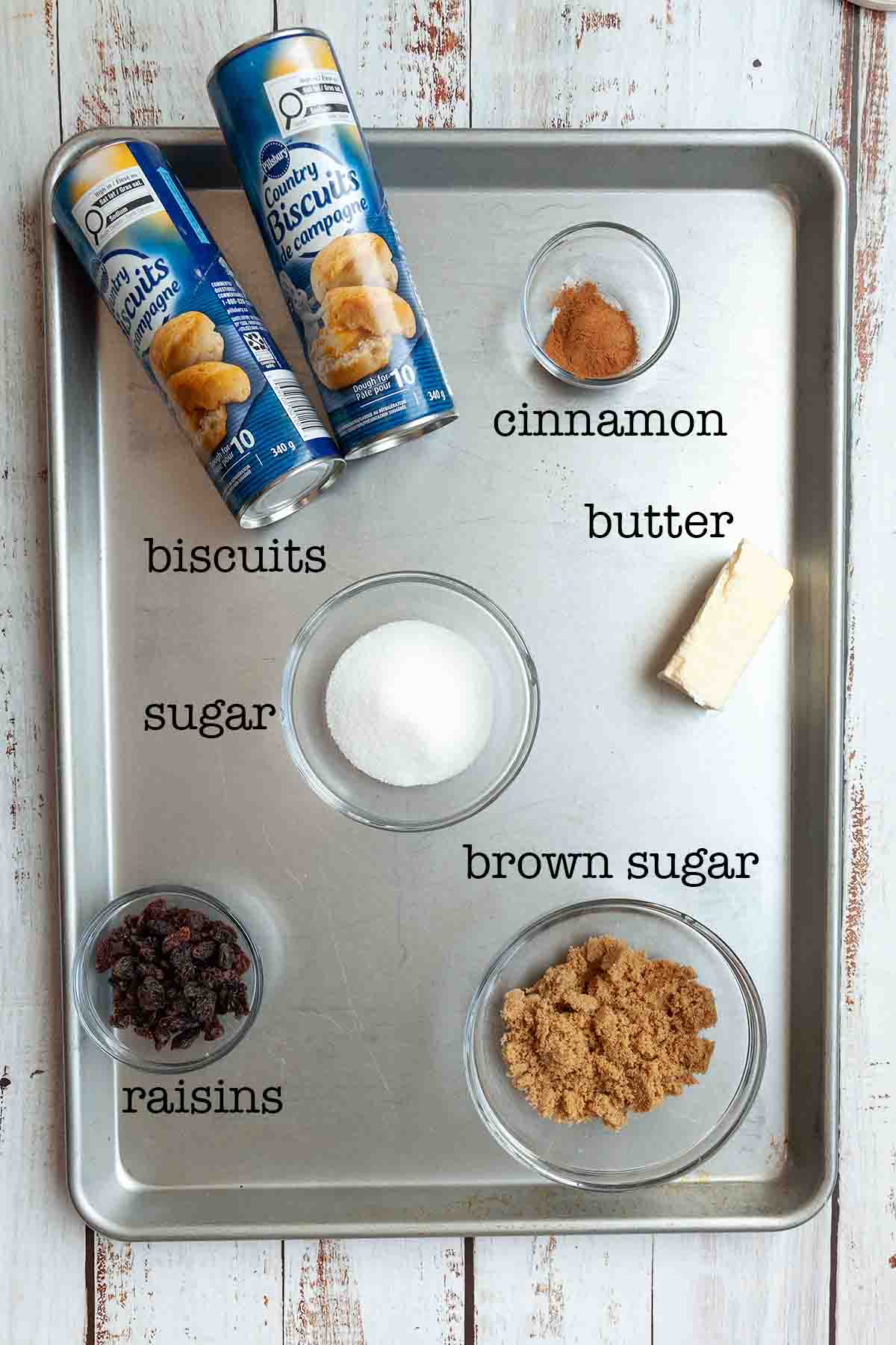 Ingredients for Dutch oven monkey bread--biscuits, cinnamon, butter, sugar, raisins, and brown sugar.