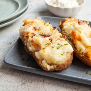A grilled twice baked potato on a platter.