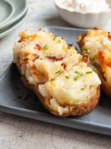 A grilled twice baked potato on a platter.