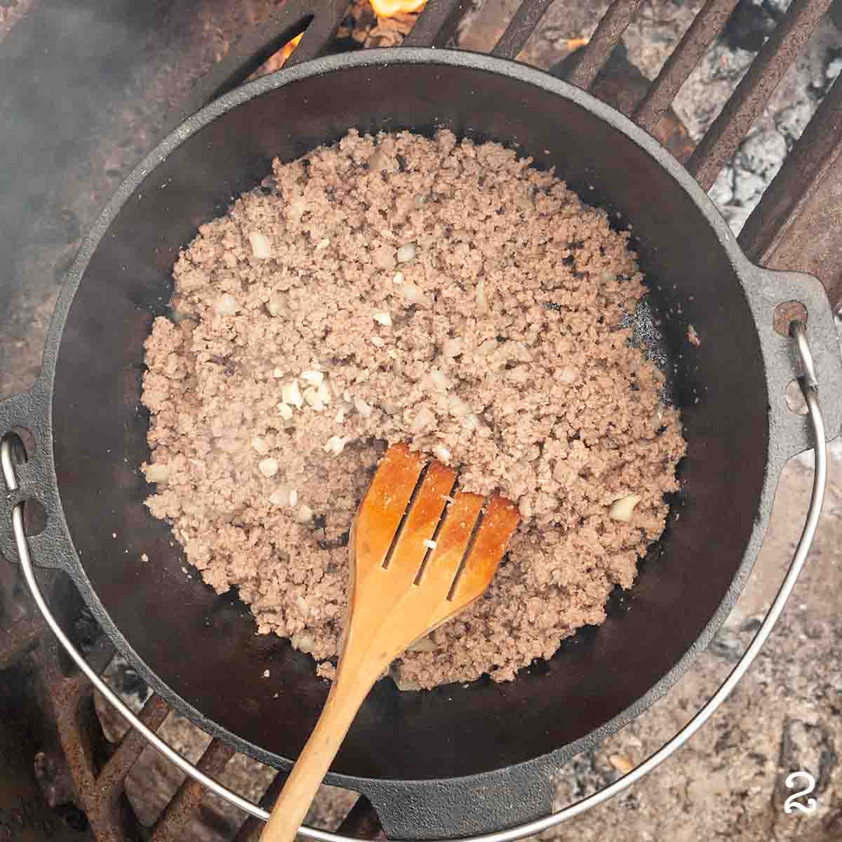 Cooked ground beef, onion, and garlic in a Dutch oven.