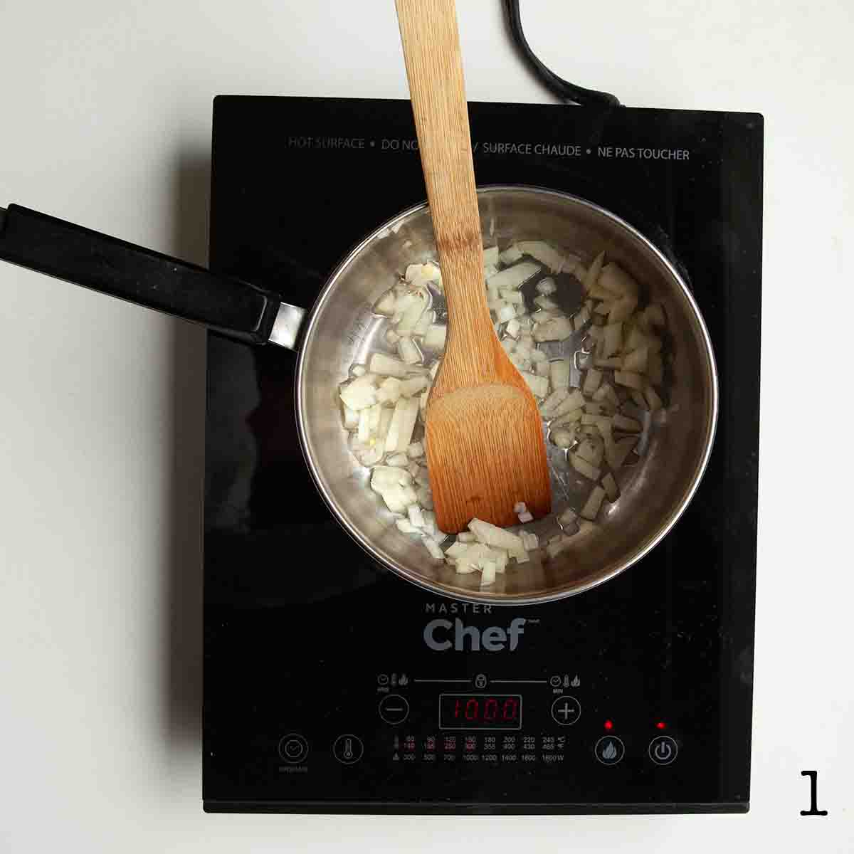 Onion being sauteed in a pot.
