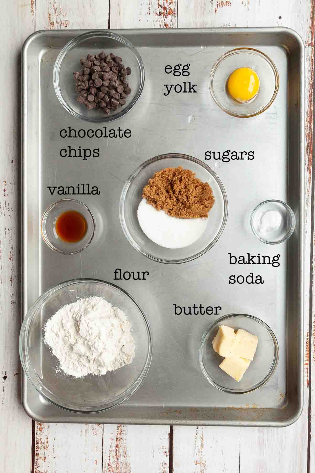 Ingredients for campfire cookies--chocolate chips, egg yolk, sugars, vanilla, flour, butter, and baking soda.