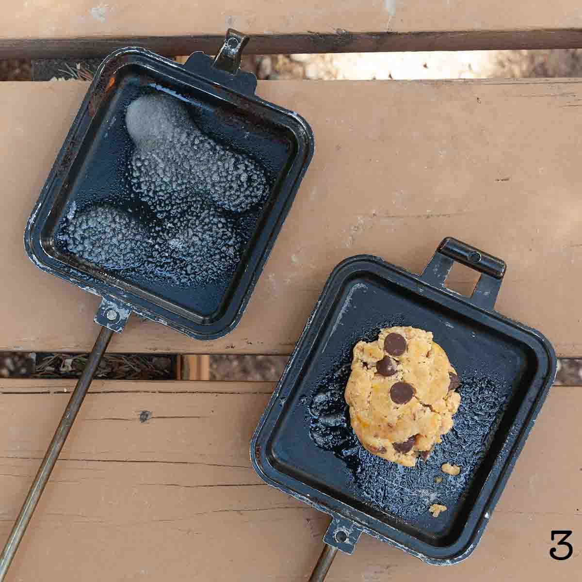A ball of cookie dough in a campfire pie iron.