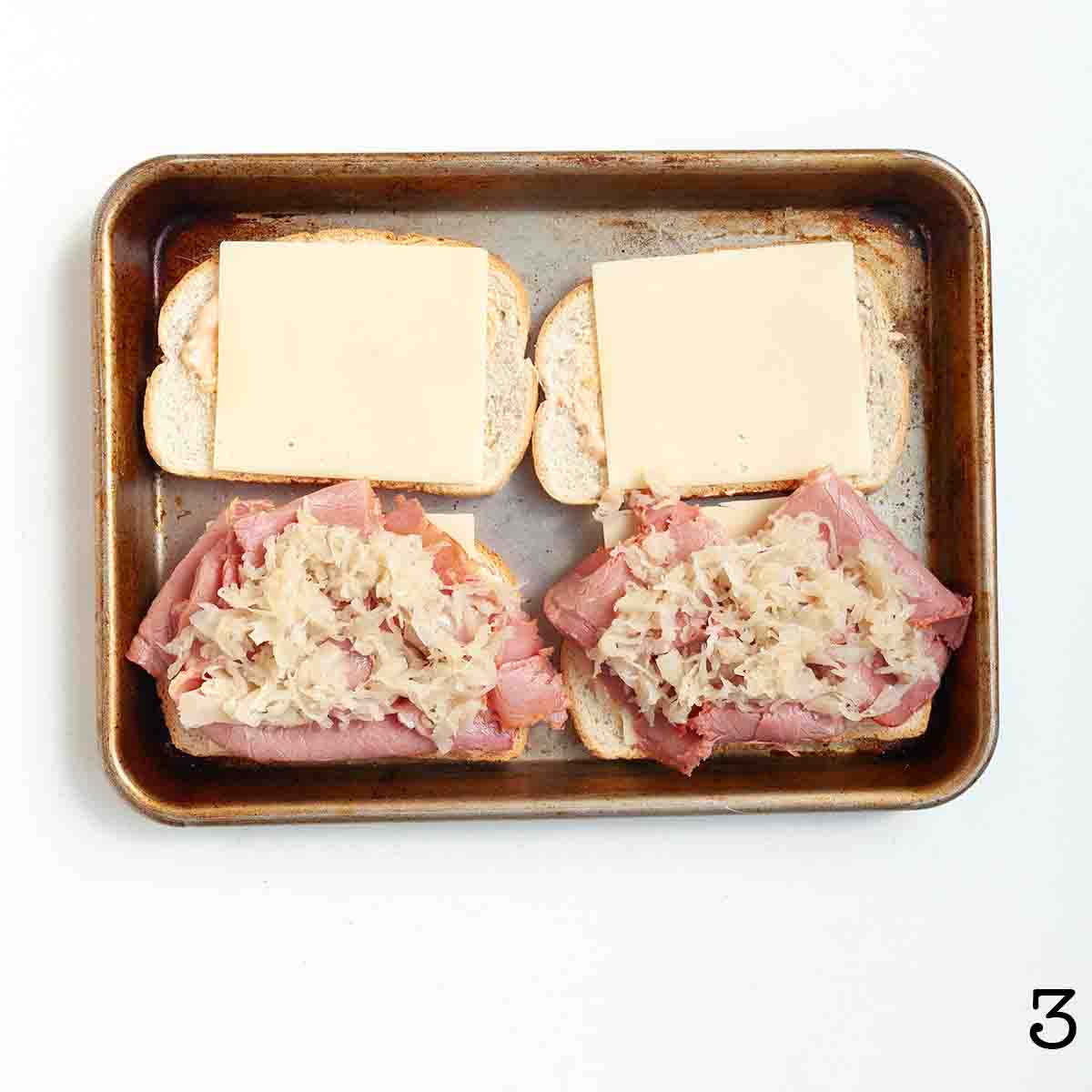 Two reuben sandwiches partially assembled.