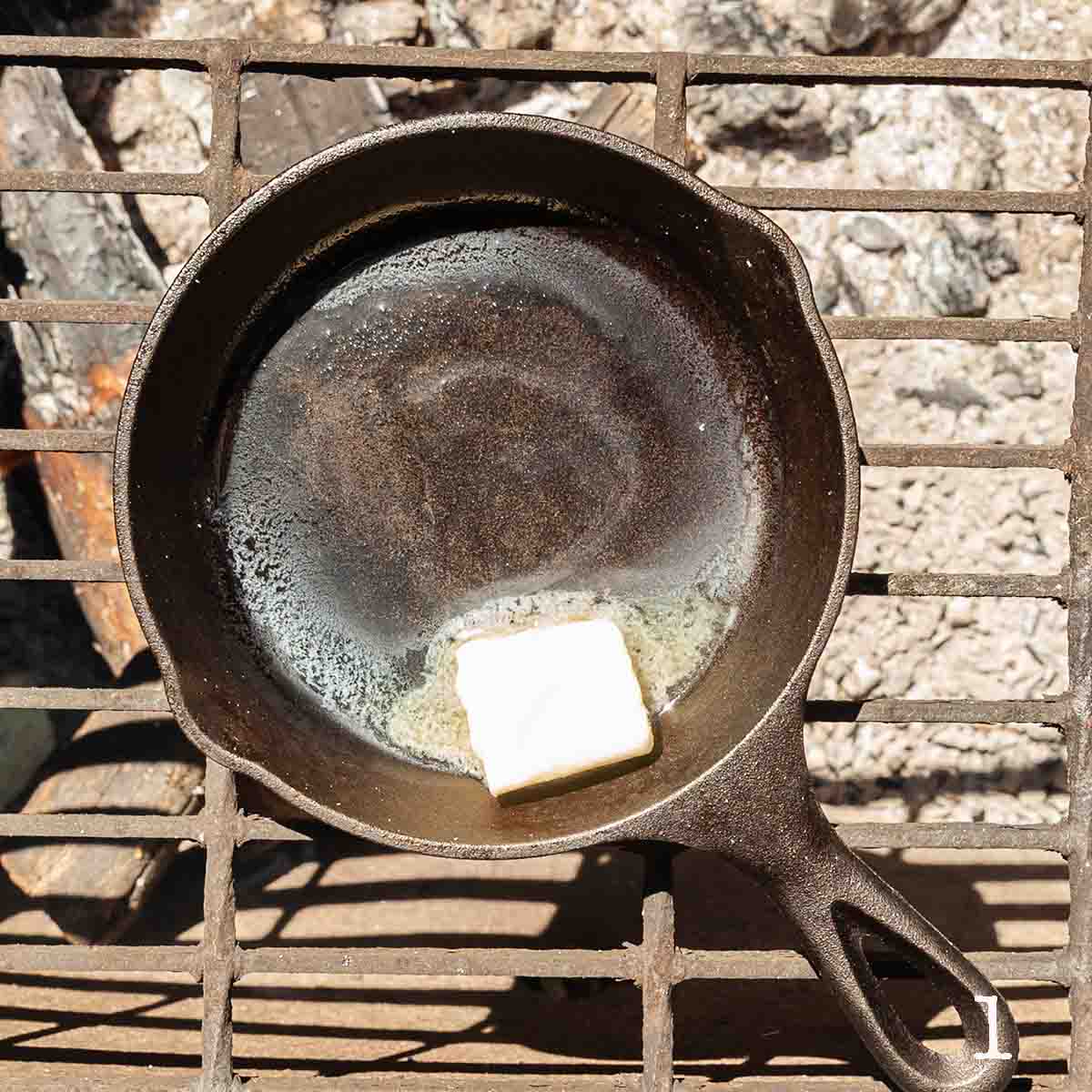Butter melting in a skillet over a fire.