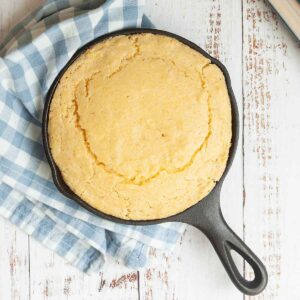 A mini cast iron skillet filled with cornbread.