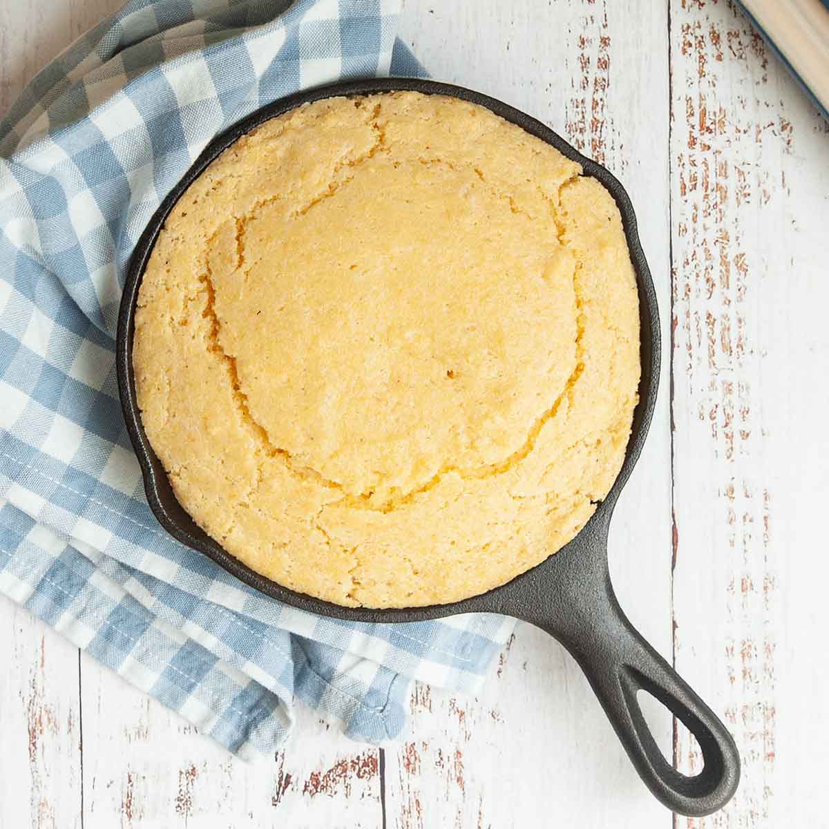 A mini cast iron skillet filled with cornbread.